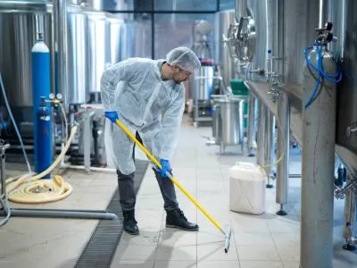 Desengraxante biodegradável sendo usado por homem para limpar o solo