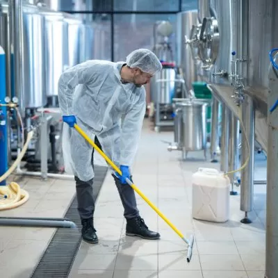 Desengraxante biodegradável sendo usado por homem para limpar o solo
