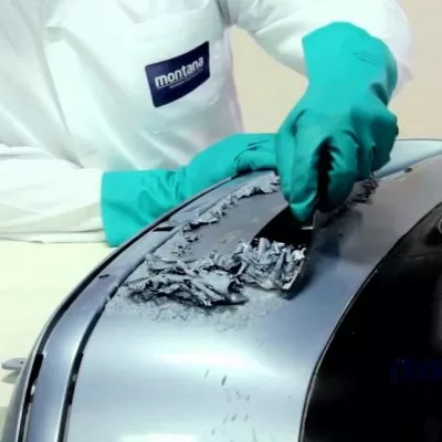 profissional aplicando decapante de tinta em parachoque