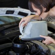 Lubrificantes mais usados: mulher colocando óleo no carro