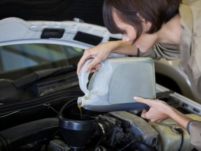 Lubrificantes mais usados: mulher colocando óleo no carro