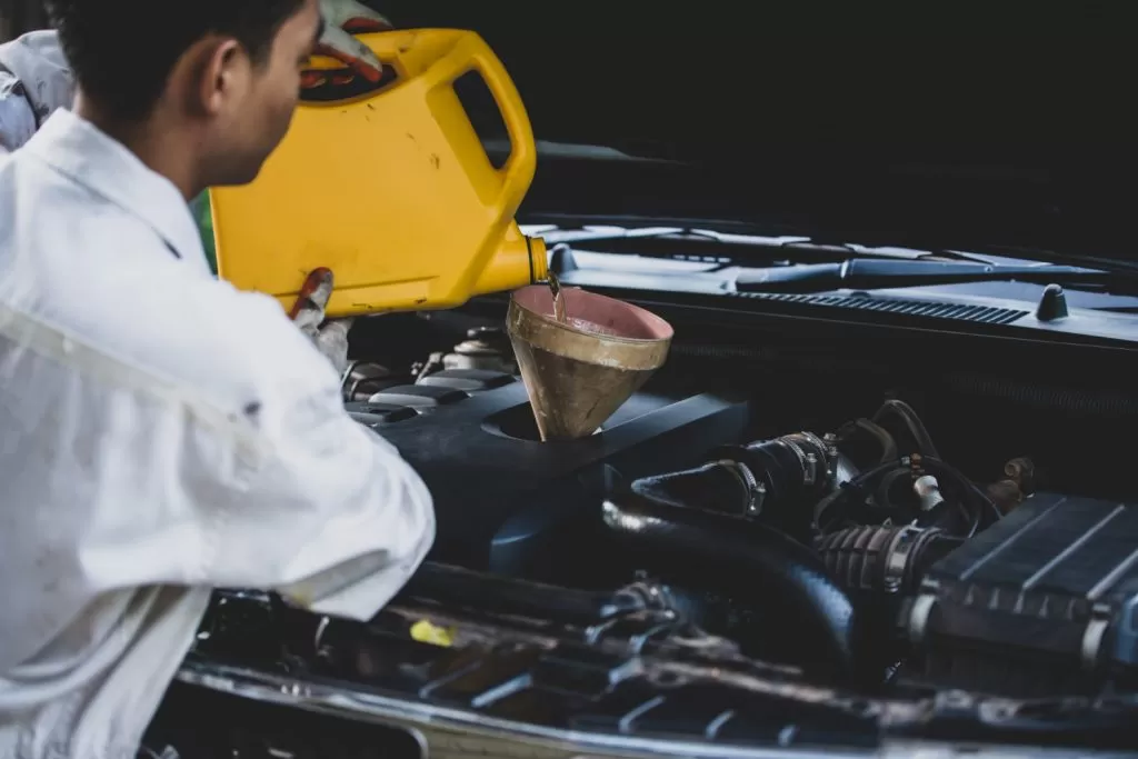como os lubrificantes reduzem o atrito: profissional trocando óleo de carro