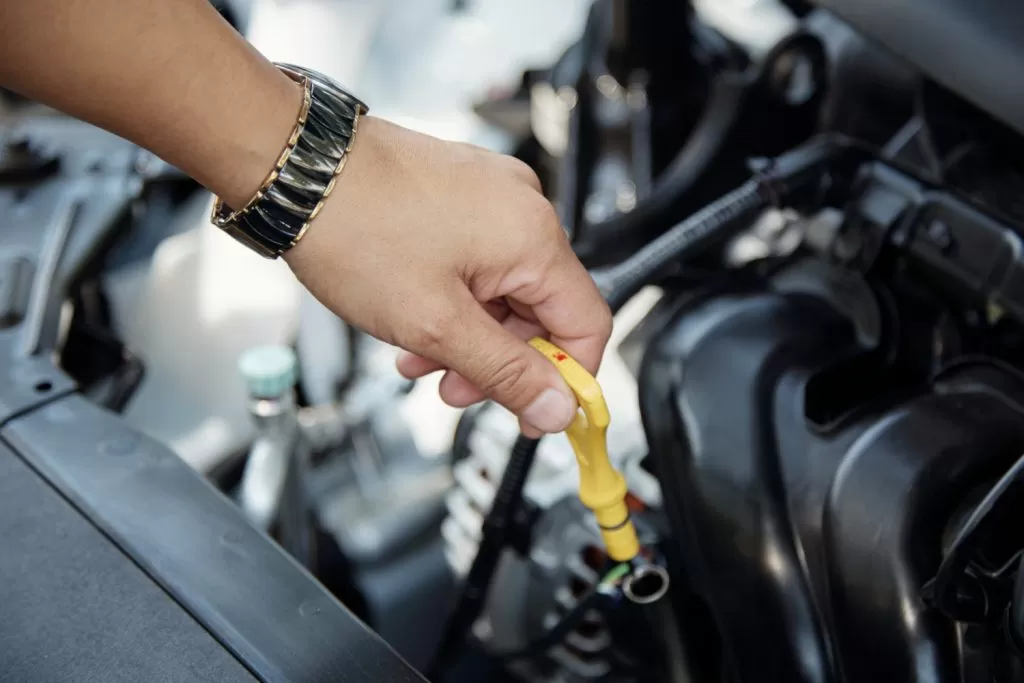 Melhor marca de óleo para motor: pessoa medindo óleo do motor