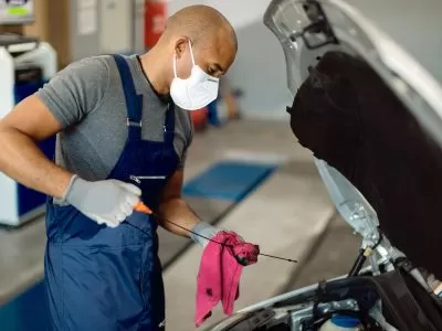 qual oleo mais grosso 20w50 ou 15w40: mecãnico trocando óleo de carro